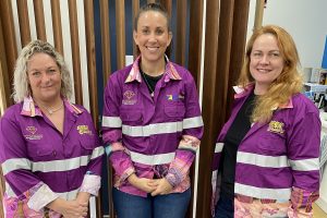 Three women in campaign shirts with indigenous designs