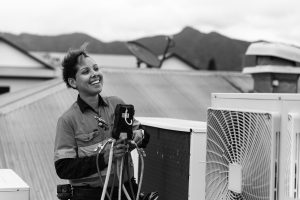 women apprentice working on a rooftop smiling
