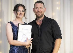 Young female graduate with teacher.